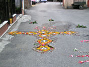 Croce di fiori sull'asfalto
